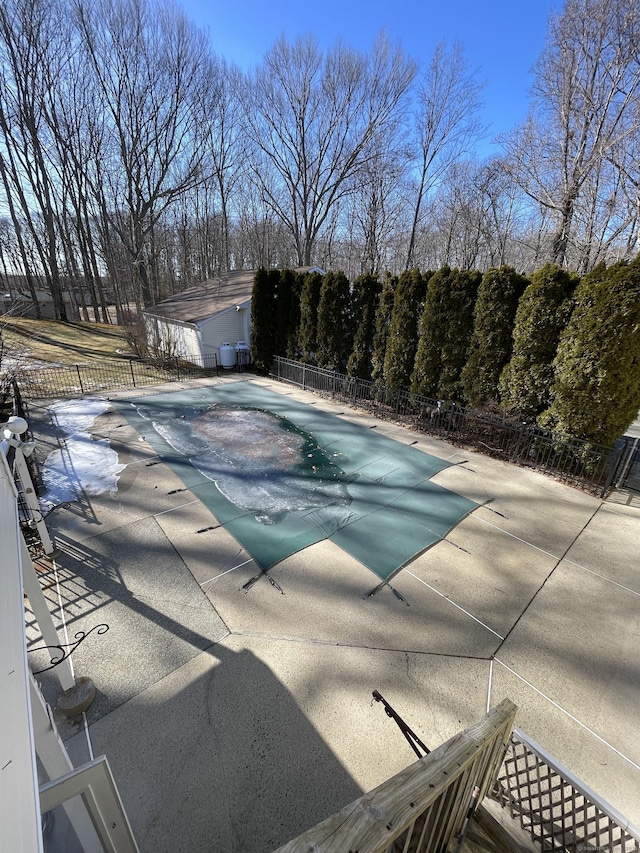 pool with a patio and fence