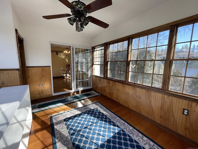 sunroom / solarium with ceiling fan with notable chandelier