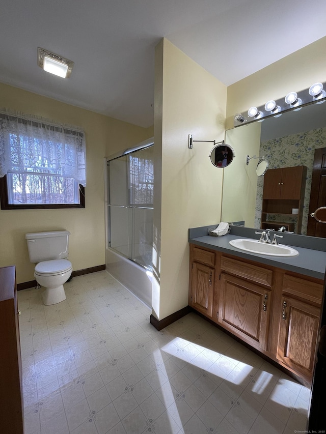 full bathroom featuring vanity, baseboards, enclosed tub / shower combo, tile patterned floors, and toilet