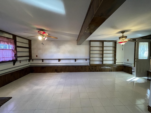 spare room featuring beam ceiling, plenty of natural light, and a ceiling fan