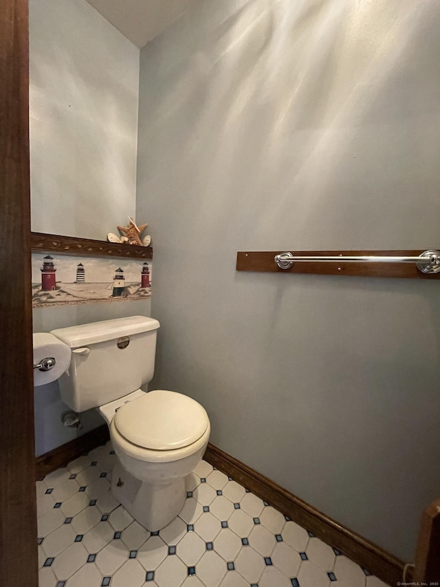 bathroom with toilet and baseboards