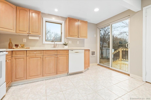 kitchen featuring a healthy amount of sunlight, dishwasher, sink, and light tile patterned floors