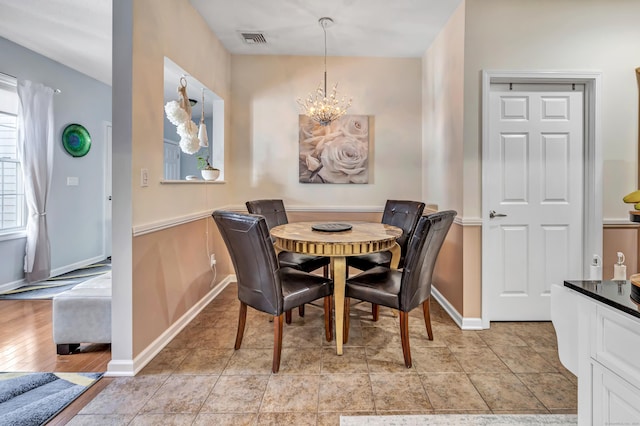 dining room featuring light tile patterned flooring and an inviting chandelier