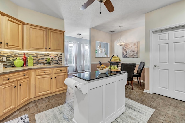 kitchen featuring ceiling fan, decorative backsplash, hanging light fixtures, and light brown cabinets