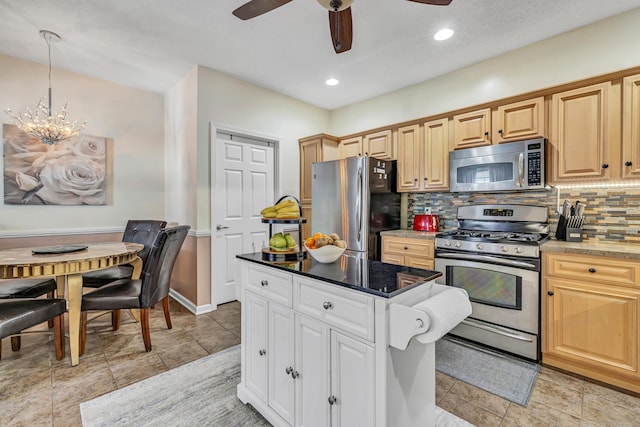 kitchen featuring pendant lighting, appliances with stainless steel finishes, backsplash, light brown cabinetry, and ceiling fan with notable chandelier