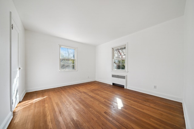 empty room featuring dark hardwood / wood-style flooring and radiator