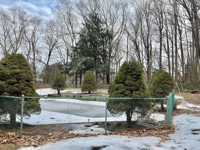 snow covered pool featuring fence