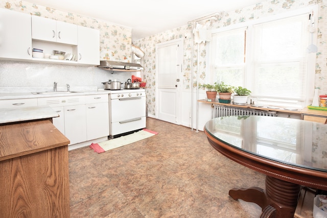 kitchen with white range with gas cooktop, sink, white cabinetry, and radiator