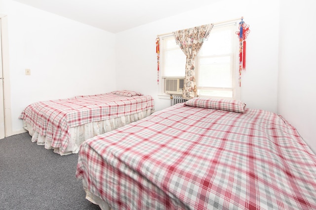 bedroom featuring cooling unit, radiator heating unit, and carpet floors