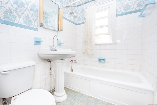 bathroom featuring tile walls, a bath, and toilet