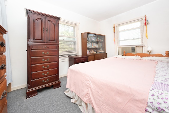 bedroom with dark colored carpet and cooling unit