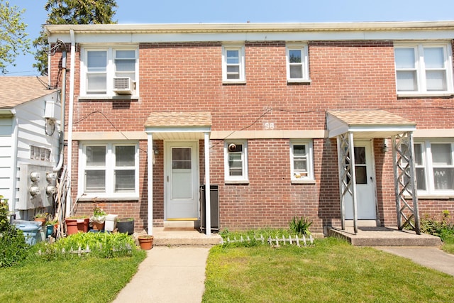 view of property featuring cooling unit and a front lawn