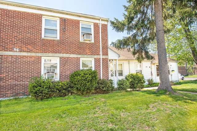 exterior space featuring cooling unit and a front lawn