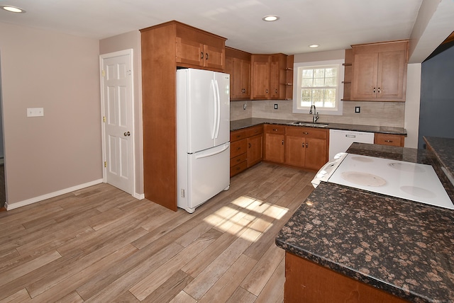 kitchen with white appliances, light hardwood / wood-style floors, sink, and decorative backsplash