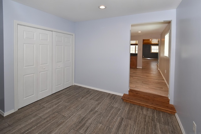 unfurnished bedroom with dark hardwood / wood-style flooring and a closet