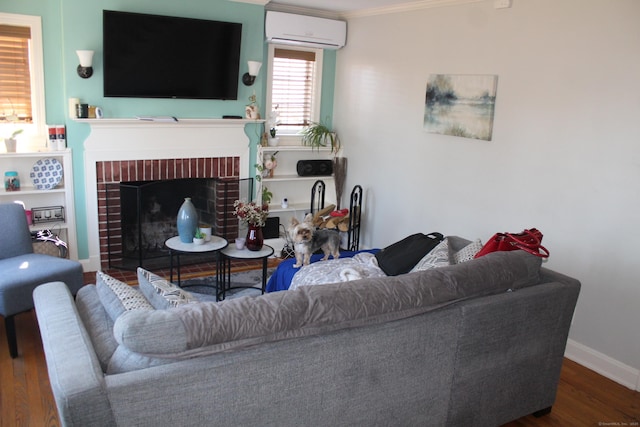 living room with crown molding, dark wood-type flooring, a fireplace, and a wall unit AC