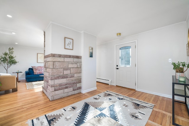 entrance foyer with baseboard heating, ornamental molding, and wood-type flooring