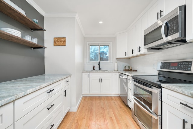 kitchen featuring white cabinetry, sink, crown molding, and stainless steel appliances