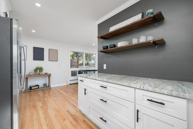 kitchen featuring crown molding, stainless steel refrigerator, baseboard heating, white cabinetry, and light stone countertops