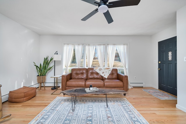 living room featuring a baseboard radiator, ceiling fan, and light wood-type flooring