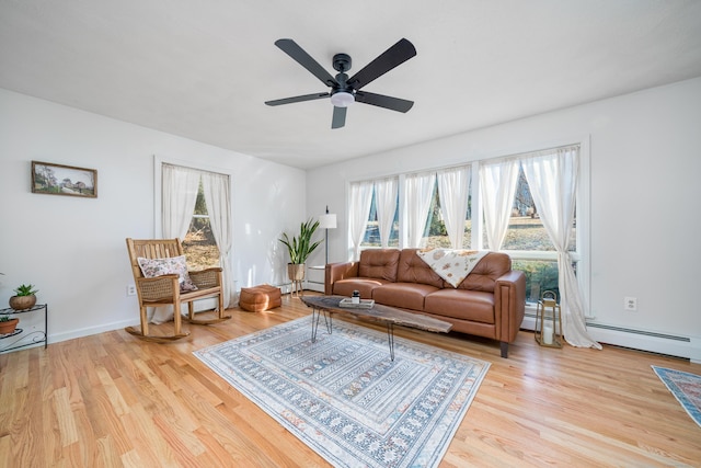 living room featuring a wealth of natural light, light hardwood / wood-style floors, and a baseboard radiator