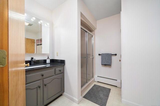 bathroom with vanity, a shower with shower door, and baseboard heating