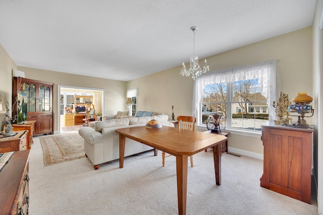 interior space featuring light colored carpet, a textured ceiling, and an inviting chandelier