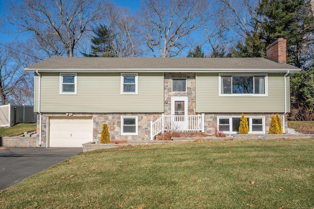 bi-level home with a garage and a front lawn