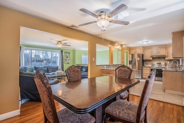 dining area with sink and light hardwood / wood-style floors