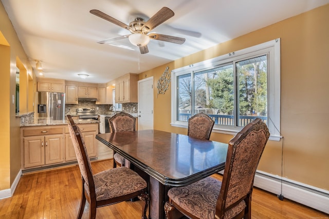 dining space featuring a baseboard radiator, light hardwood / wood-style floors, and ceiling fan