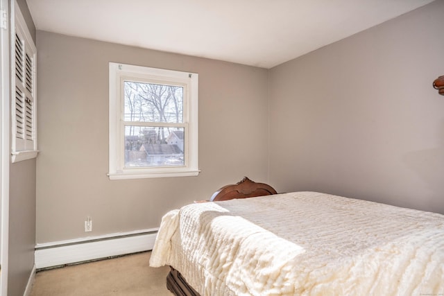 bedroom with baseboard heating and light carpet