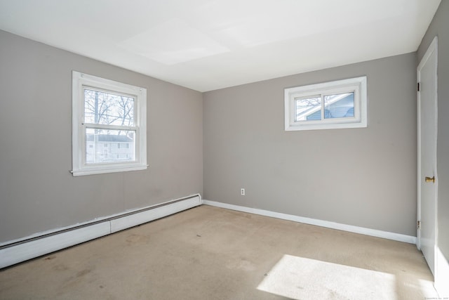 carpeted empty room with a baseboard heating unit and plenty of natural light