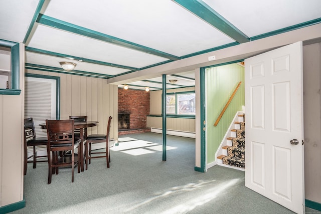 sunroom / solarium featuring beam ceiling, a baseboard radiator, and a fireplace