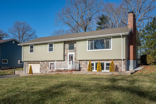 split foyer home with a garage and a front lawn