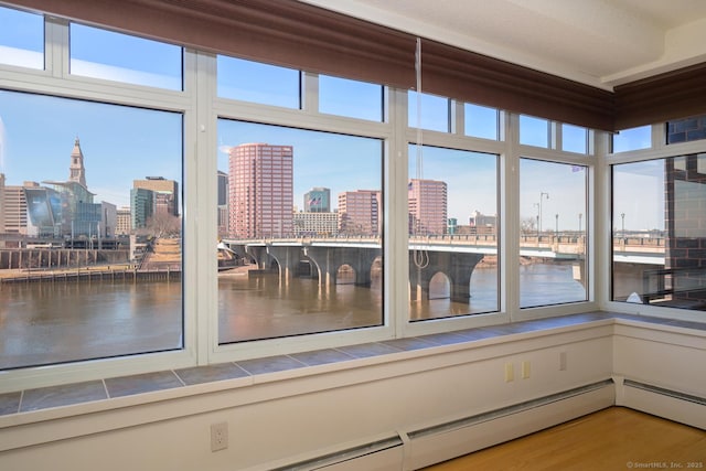 unfurnished sunroom with a city view and a water view