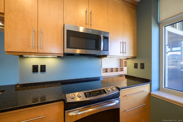 kitchen with dark stone countertops and appliances with stainless steel finishes