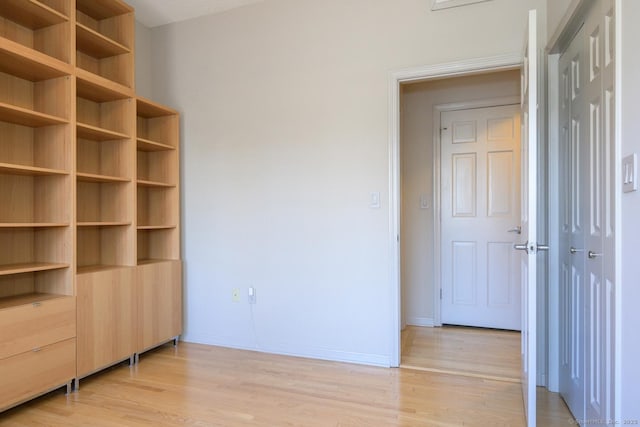 unfurnished bedroom with baseboards and light wood finished floors