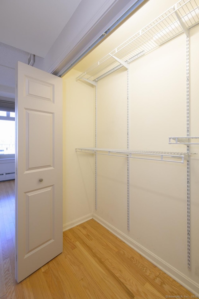 walk in closet with baseboard heating and light wood-style floors