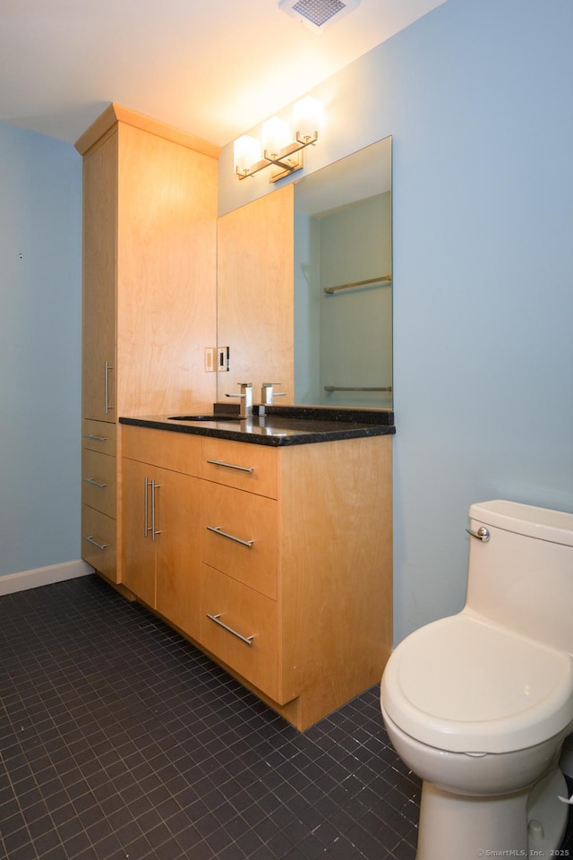 bathroom featuring tile patterned floors, baseboards, toilet, and vanity