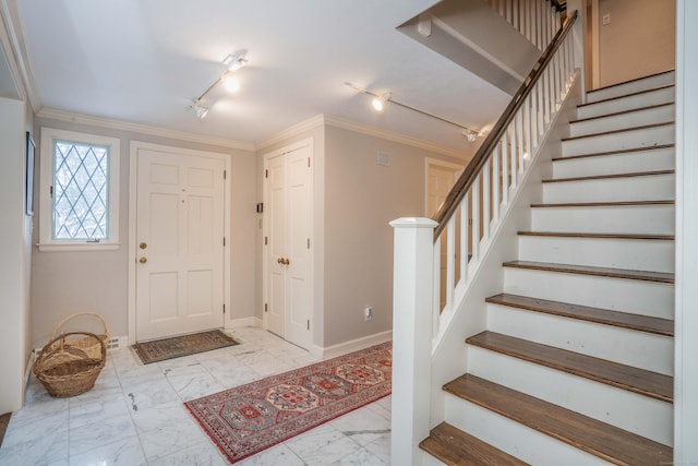 entrance foyer with crown molding and track lighting