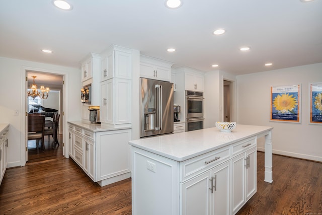 kitchen featuring a kitchen island, white cabinetry, appliances with stainless steel finishes, and dark hardwood / wood-style floors