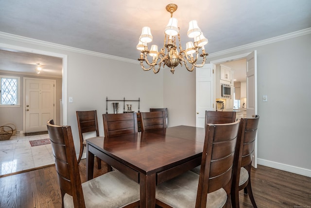 dining room with hardwood / wood-style flooring, crown molding, and a notable chandelier