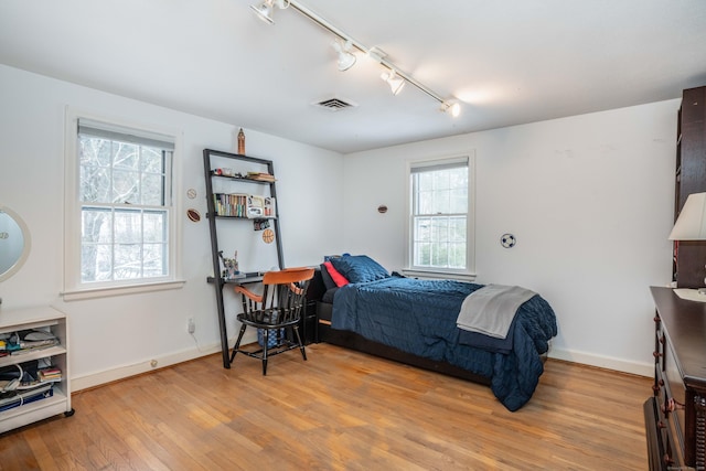 bedroom with hardwood / wood-style flooring and rail lighting