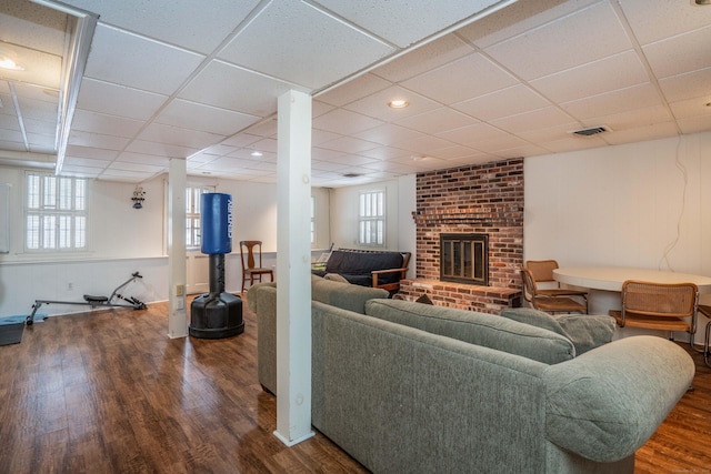 living room with hardwood / wood-style flooring, a fireplace, and a paneled ceiling