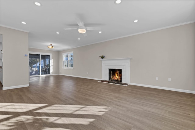 unfurnished living room with a brick fireplace, ornamental molding, light hardwood / wood-style floors, and ceiling fan