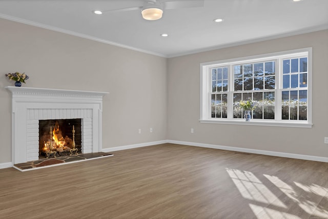 unfurnished living room with hardwood / wood-style flooring, ornamental molding, and a fireplace