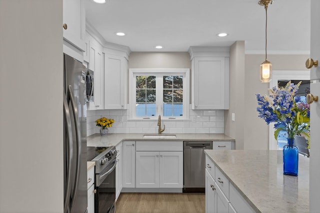 kitchen with white cabinetry, appliances with stainless steel finishes, sink, and pendant lighting