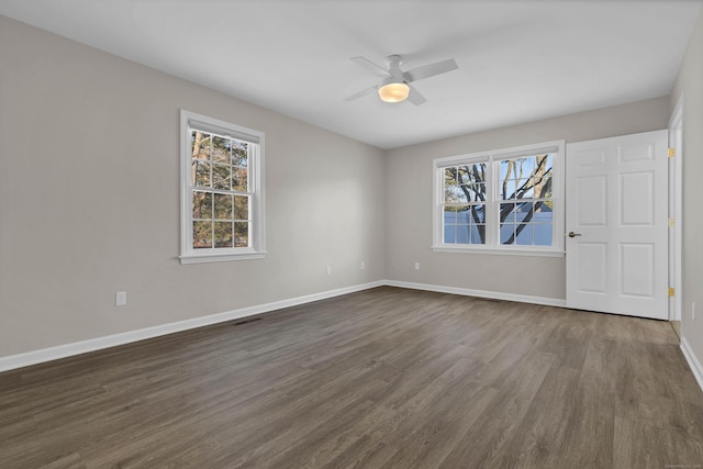 unfurnished room featuring plenty of natural light and dark hardwood / wood-style floors