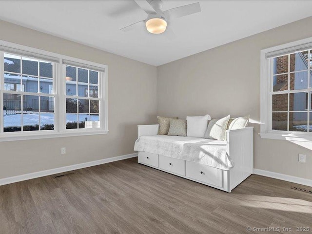 unfurnished room featuring wood-type flooring, a wealth of natural light, and ceiling fan