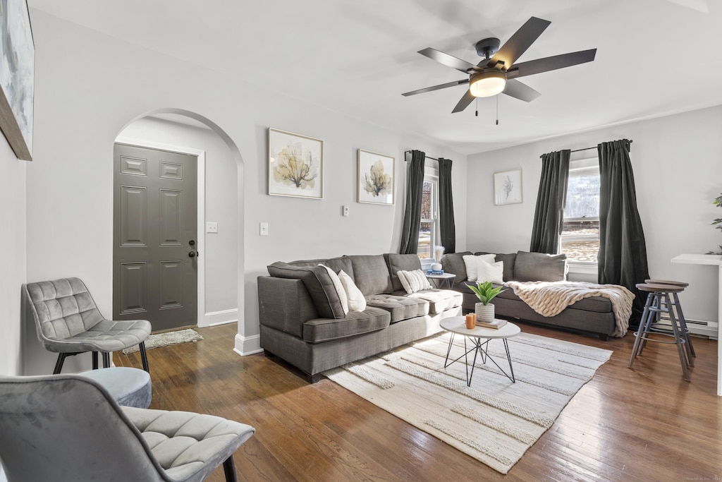 living room with ceiling fan and dark hardwood / wood-style flooring